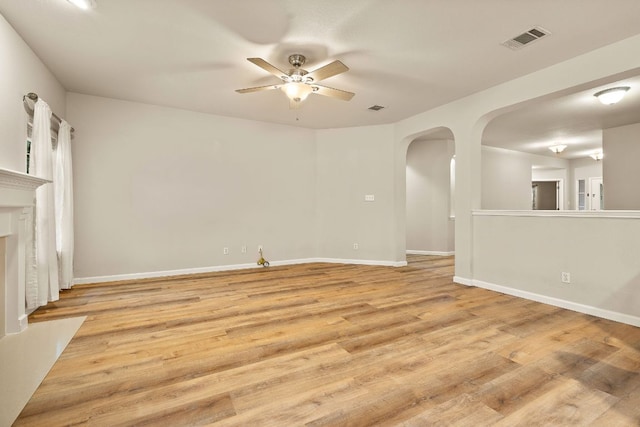 10804 N Canoa Hills Trl, Austin, TX 78717 - unfurnished living room featuring a ceiling fan, arched walkways, and light wood-style flooring