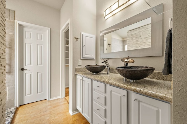 10804 N Canoa Hills Trl, Austin, TX 78717 - full bathroom featuring double vanity, wood finished floors, and a spacious closet