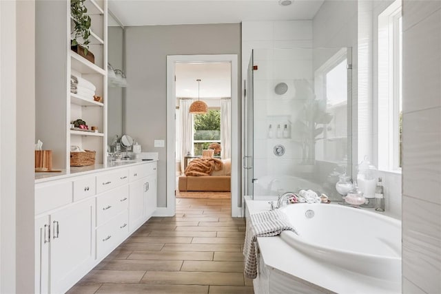 12404 Cardinal Flower Dr, Austin, TX 78739 - ensuite bathroom featuring a bath, a shower stall, vanity, and wood finished floors