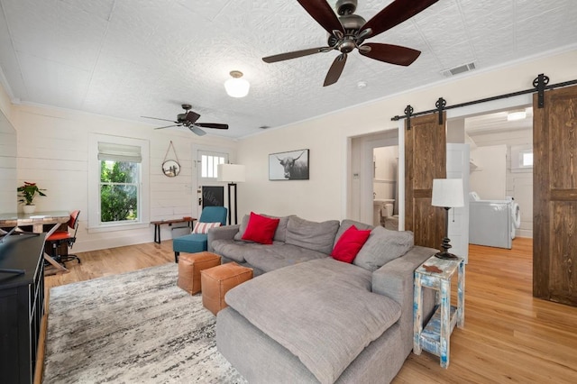 1700 S 3rd St, Austin, TX 78704 - living area with a barn door, a ceiling fan, light wood-type flooring, and independent washer and dryer