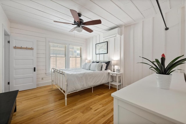 1700 S 3rd St, Austin, TX 78704 - bedroom featuring an AC wall unit, light wood-style flooring, wooden ceiling, and ceiling fan