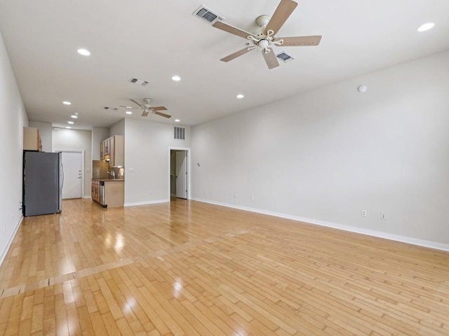 2931 E 12th St Unit 206, Austin, TX 78702 - unfurnished living room featuring ceiling fan, light wood finished floors, baseboards, recessed lighting, and a sink