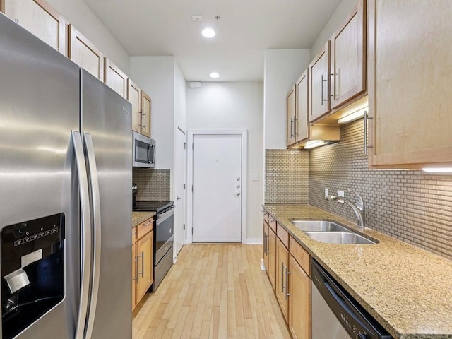 2931 E 12th St Unit 206, Austin, TX 78702 - kitchen with stainless steel appliances, a sink, backsplash, light stone countertops, and recessed lighting