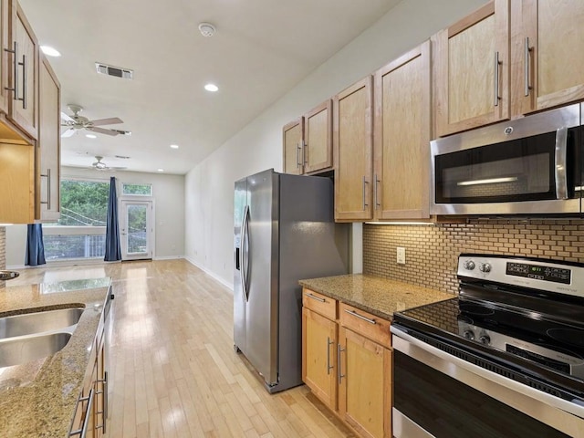 2931 E 12th St Unit 206, Austin, TX 78702 - kitchen featuring stainless steel appliances, backsplash, a ceiling fan, light stone countertops, and light wood-type flooring