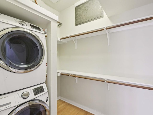 2931 E 12th St Unit 206, Austin, TX 78702 - laundry area with stacked washer / drying machine, light wood-style flooring, and baseboards