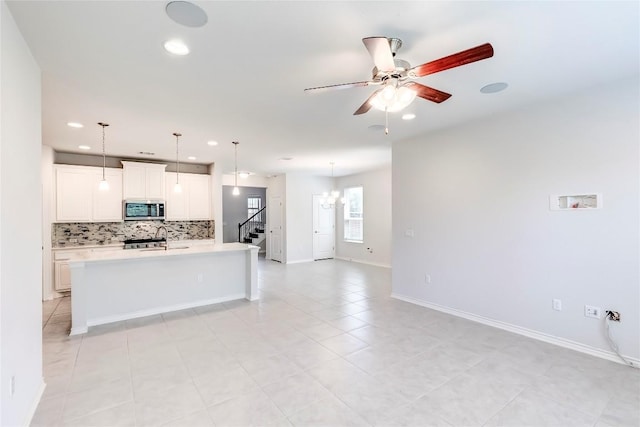 14400 Mccoy Loop, Austin, TX 78717 - kitchen featuring stainless steel microwave, decorative backsplash, light countertops, ceiling fan, and recessed lighting
