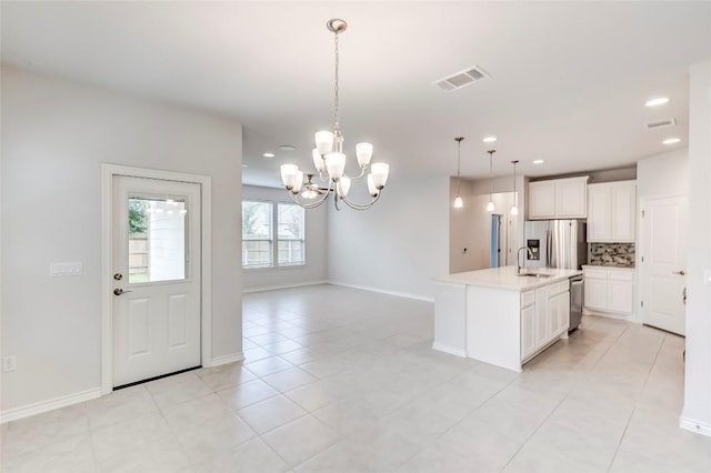 14400 Mccoy Loop, Austin, TX 78717 - kitchen featuring stainless steel appliances, backsplash, a chandelier, white cabinets, and light countertops