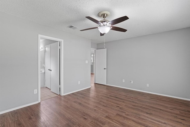 913 Dover Pass, Cedar Park, TX 78613 - unfurnished bedroom featuring wood finished floors, baseboards, a textured ceiling, a ceiling fan, and connected bathroom