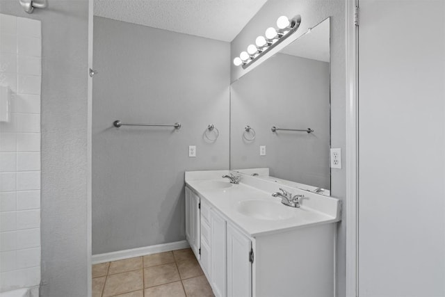 913 Dover Pass, Cedar Park, TX 78613 - bathroom featuring double vanity, tile patterned flooring, a textured ceiling, and baseboards