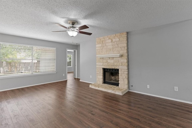 913 Dover Pass, Cedar Park, TX 78613 - unfurnished living room with a ceiling fan, a textured ceiling, dark wood finished floors, a fireplace, and baseboards