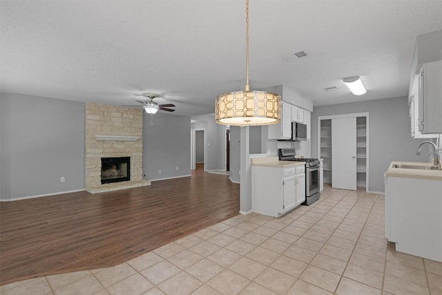 913 Dover Pass, Cedar Park, TX 78613 - kitchen featuring stainless steel appliances, a sink, light countertops, a ceiling fan, and light wood-style floors