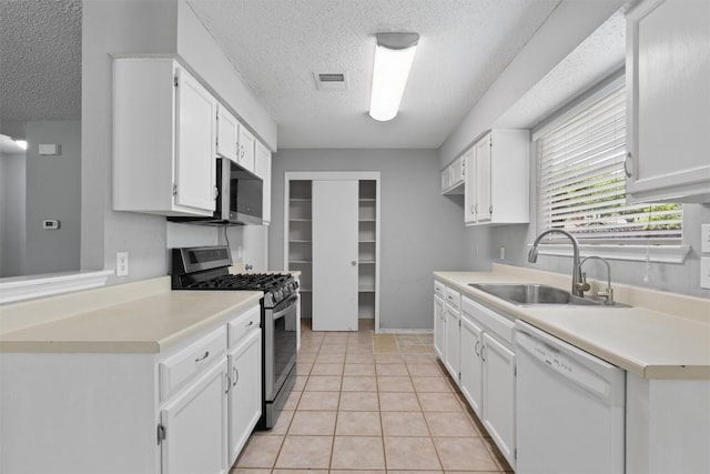 913 Dover Pass, Cedar Park, TX 78613 - kitchen with appliances with stainless steel finishes, a sink, a textured ceiling, light countertops, and white cabinetry