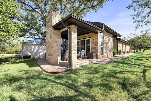 2606 Deep Cyn, Horseshoe Bay, TX 78657 - rear view of house with a chimney, stone siding, and a yard