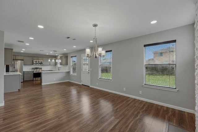 339 Precipice Way, Georgetown, TX 78626 - unfurnished living room with a chandelier, baseboards, dark wood-style floors, and recessed lighting