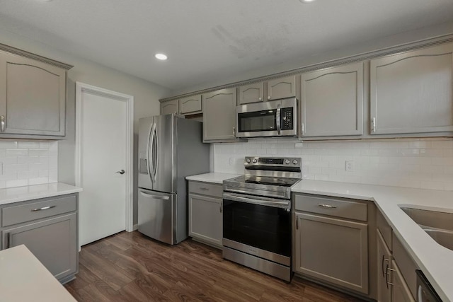 339 Precipice Way, Georgetown, TX 78626 - kitchen featuring appliances with stainless steel finishes, gray cabinetry, decorative backsplash, recessed lighting, and dark wood-style floors