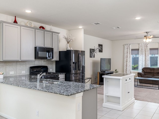 1213 Whipple Tree Trl, Georgetown, TX 78626 - kitchen with black microwave, stainless steel fridge, gas range oven, open floor plan, and a ceiling fan
