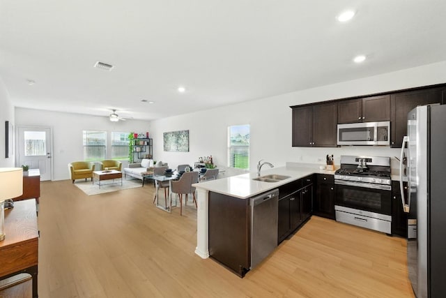 7506 Grenadine Bloom Bnd, Del Valle, TX 78617 - kitchen featuring appliances with stainless steel finishes, open floor plan, light wood finished floors, a sink, and recessed lighting