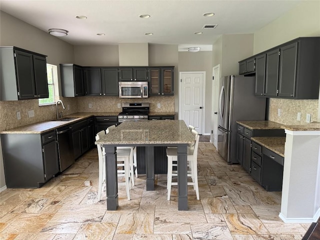 2606 Melba Pass, Cedar Park, TX 78613 - kitchen with stainless steel appliances, a sink, tasteful backsplash, baseboards, and light stone counters