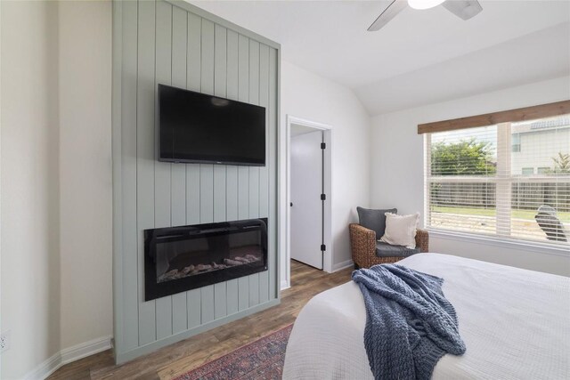 309 Callahan Ln, Leander, TX 78641 - bedroom with wood finished floors, lofted ceiling, baseboards, a fireplace, and a ceiling fan