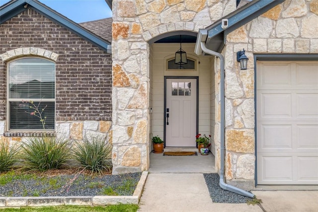 309 Callahan Ln, Leander, TX 78641 - entrance to property featuring stone siding, an attached garage, and roof with shingles