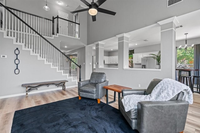 120 Spring Ct, Georgetown, TX 78633 - living area with decorative columns, stairway, wood finished floors, plenty of natural light, and a towering ceiling