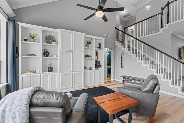 120 Spring Ct, Georgetown, TX 78633 - living room with a ceiling fan, light wood-style flooring, high vaulted ceiling, stairs, and ornamental molding