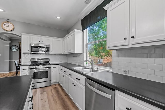120 Spring Ct, Georgetown, TX 78633 - kitchen featuring stainless steel appliances, a sink, dark countertops, white cabinets, and tasteful backsplash