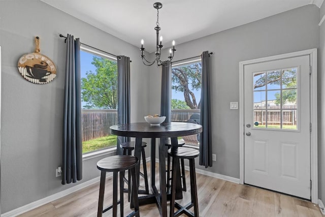 120 Spring Ct, Georgetown, TX 78633 - dining room with a chandelier, light wood-style floors, and baseboards