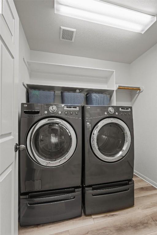120 Spring Ct, Georgetown, TX 78633 - laundry room featuring separate washer and dryer, wood finished floors, and baseboards