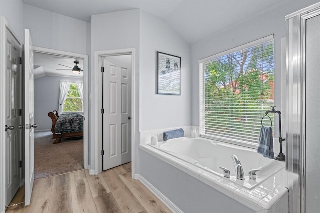 120 Spring Ct, Georgetown, TX 78633 - ensuite bathroom with lofted ceiling, a bath, wood finished floors, and a ceiling fan