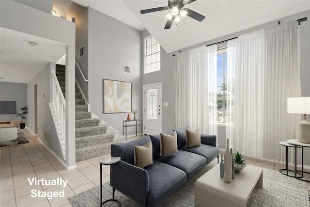 902 Valley Glen Cv, Pflugerville, TX 78660 - living room with light tile patterned flooring, stairway, a ceiling fan, healthy amount of natural light, and a towering ceiling