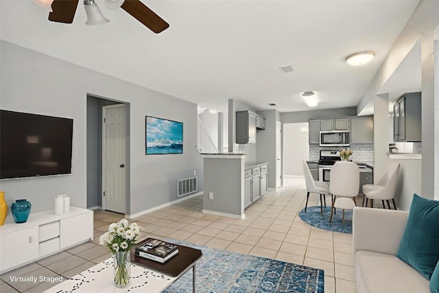 902 Valley Glen Cv, Pflugerville, TX 78660 - living area with a ceiling fan, light tile patterned floors, baseboards, and stairway
