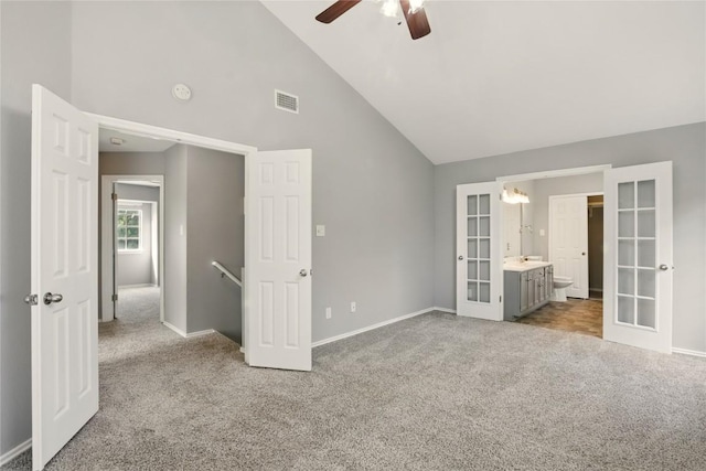 902 Valley Glen Cv, Pflugerville, TX 78660 - unfurnished bedroom featuring french doors, carpet flooring, baseboards, high vaulted ceiling, and connected bathroom
