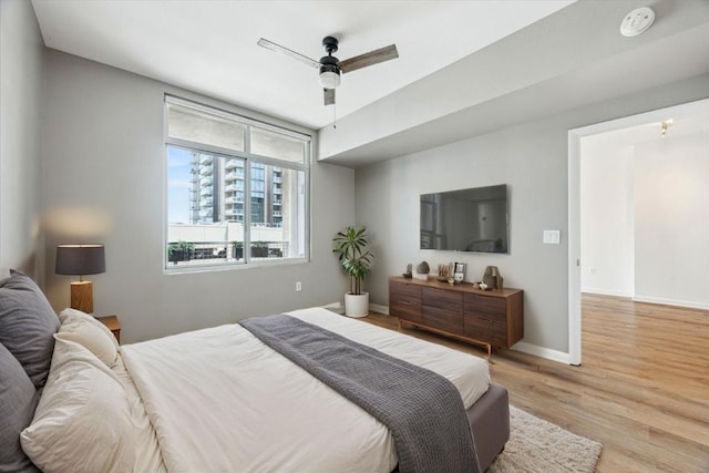54 Rainey St Unit 815, Austin, TX 78701 - bedroom with light wood-type flooring, baseboards, and ceiling fan