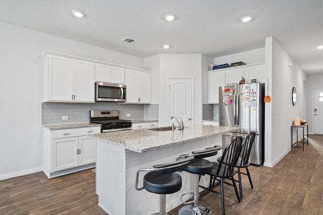204 Connor Ln, Georgetown, TX 78626 - kitchen with stainless steel appliances, a sink, dark wood-style floors, white cabinetry, and recessed lighting