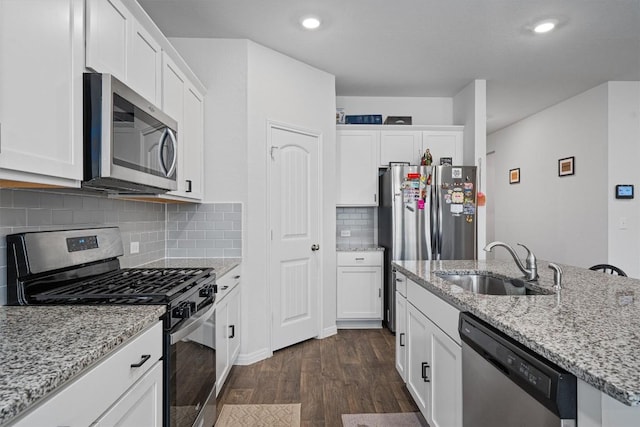 204 Connor Ln, Georgetown, TX 78626 - kitchen with stainless steel appliances, a sink, dark wood-style floors, white cabinets, and recessed lighting