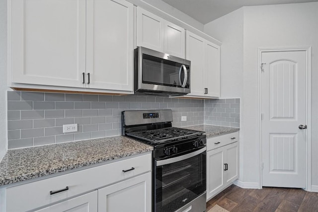 204 Connor Ln, Georgetown, TX 78626 - kitchen with appliances with stainless steel finishes, light stone counters, white cabinets, dark wood-style floors, and tasteful backsplash
