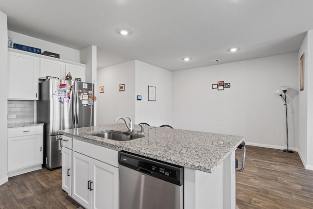 204 Connor Ln, Georgetown, TX 78626 - kitchen featuring appliances with stainless steel finishes, a sink, a kitchen island with sink, dark wood-type flooring, and white cabinetry