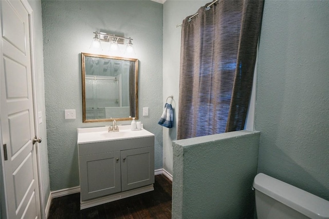 793 N Houston Ave, New Braunfels, TX 78130 - bathroom featuring wood finished floors, vanity, toilet, a textured wall, and baseboards