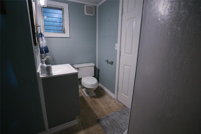 793 N Houston Ave, New Braunfels, TX 78130 - half bathroom featuring vanity, toilet, wood finished floors, ornamental molding, and baseboards