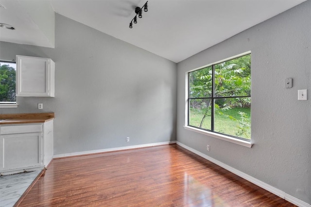 1806 Krizan Ave, Austin, TX 78727 - unfurnished dining area with vaulted ceiling, light wood-style flooring, and baseboards