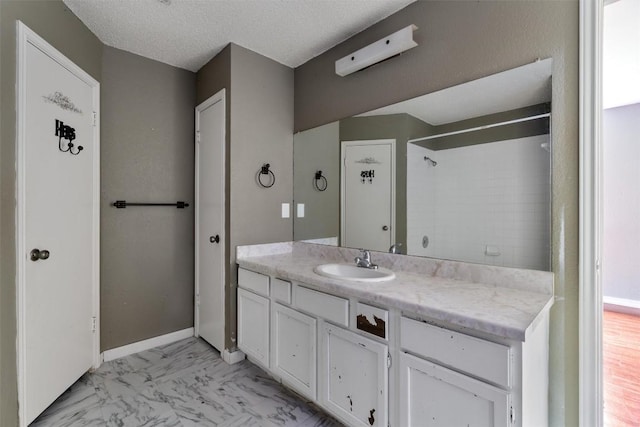 1806 Krizan Ave, Austin, TX 78727 - full bathroom with vanity, a shower, marble finish flooring, and a textured ceiling