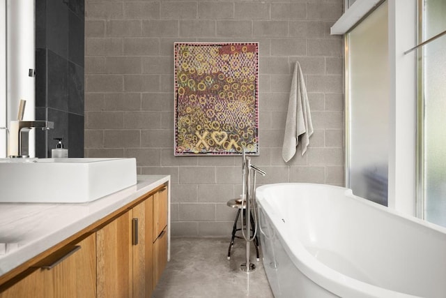 1003 E 8th St, Austin, TX 78702 - bathroom featuring concrete floors, a freestanding tub, vanity, and tile walls