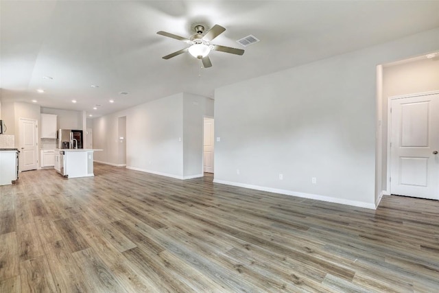 2824 Smokehouse Trl, Round Rock, TX 78665 - unfurnished living room with a ceiling fan, light wood-type flooring, baseboards, and recessed lighting