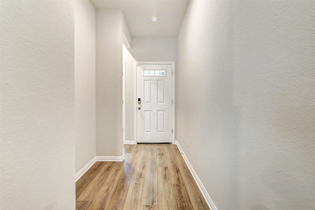 2824 Smokehouse Trl, Round Rock, TX 78665 - doorway to outside featuring light wood-type flooring, baseboards, and a textured wall