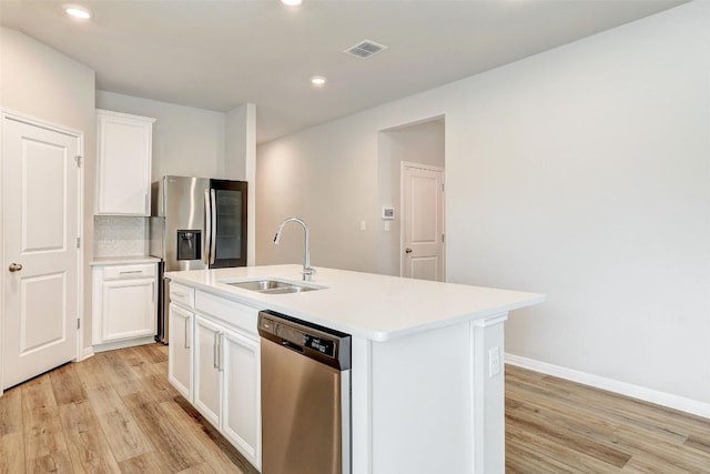 2824 Smokehouse Trl, Round Rock, TX 78665 - kitchen featuring appliances with stainless steel finishes, a sink, light wood-style floors, an island with sink, and recessed lighting