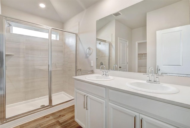 2824 Smokehouse Trl, Round Rock, TX 78665 - bathroom with a shower stall, a spacious closet, double vanity, and wood finished floors