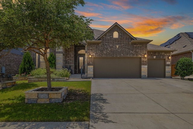 20012 Moorlynch Ave, Pflugerville, TX 78660 - view of front of property featuring a garage, concrete driveway, brick siding, stone siding, and a lawn