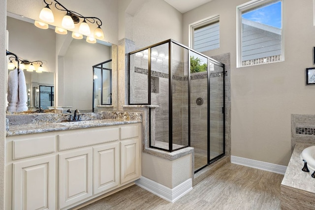 20012 Moorlynch Ave, Pflugerville, TX 78660 - bathroom featuring wood finished floors, a stall shower, vanity, and a bathtub