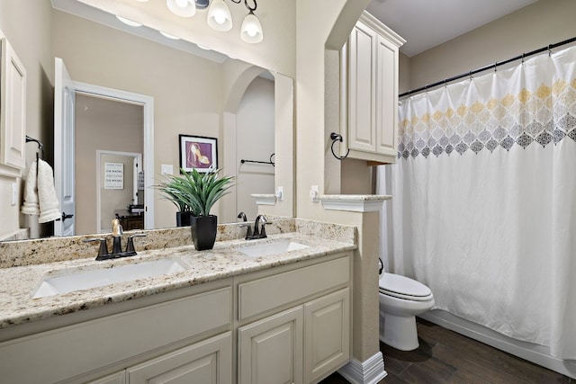 20012 Moorlynch Ave, Pflugerville, TX 78660 - bathroom with double vanity, wood finished floors, and a shower with curtain